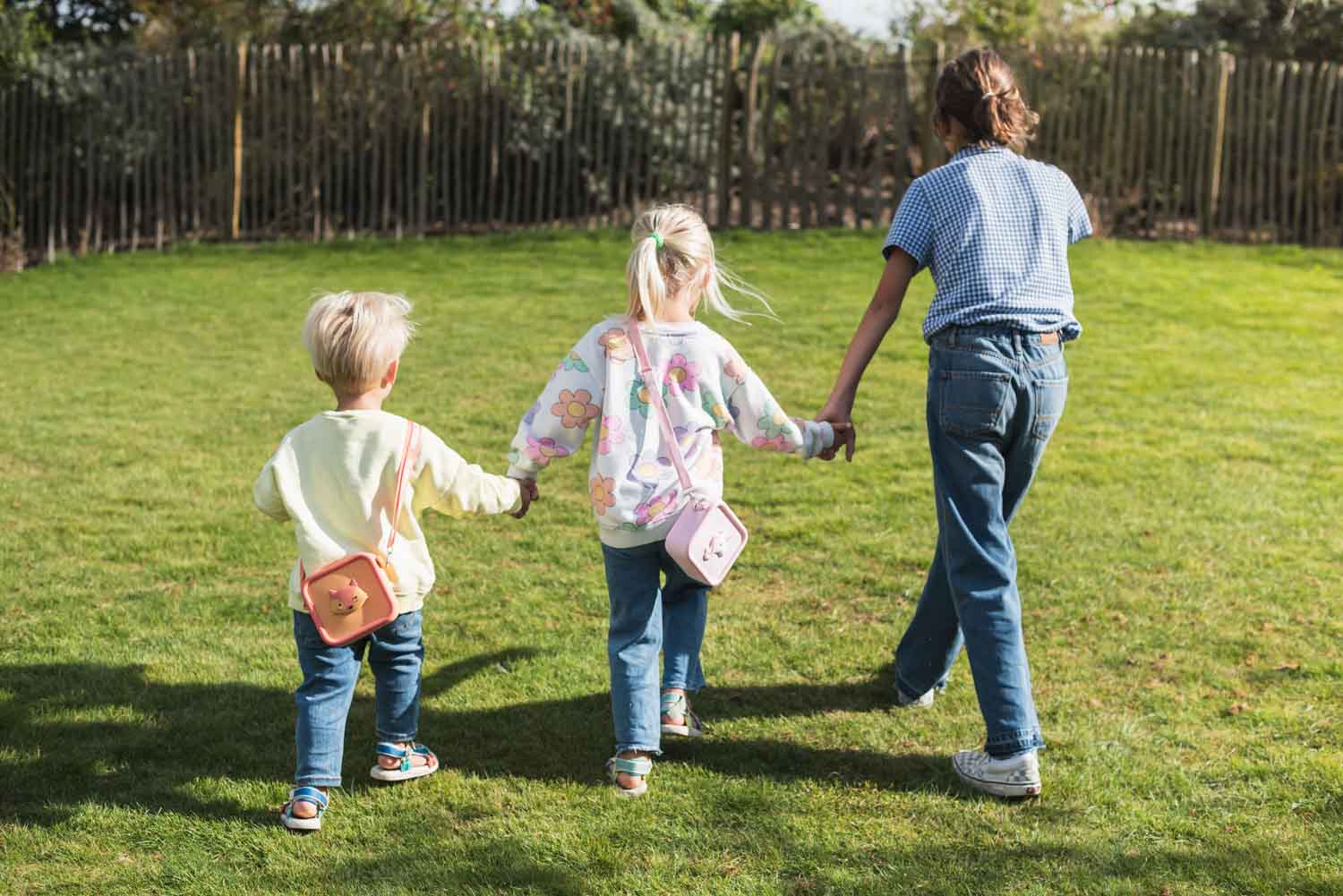 silicon bag fox and unicorn, kids are carrying the bags around their necks while walking in the garden, hand in hand