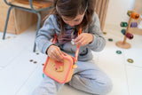 odalsilicon bag fox, child is carrying the bag around its neck while sitting in kidsroom