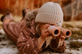 odalThe girl is lying on the barely snow-covered grass, propped up on her elbows, looking through binoculars.