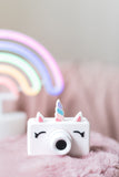 odalunicorn kids camera, on pillow, soft rainbow colors at the back