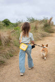 odalsilicon bag rabbit flower, child is carrying the bag over its shoulder while walking at the beach with a dog