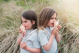 odalzoo walkie talkie set dino pink, children are standing between the dune grass, playing with the walkie talkies